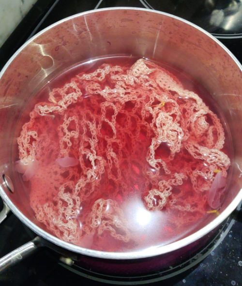 A market bag in a pot of magenta water